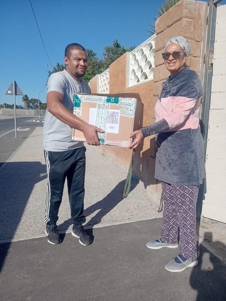 A box of sandwiches lands at the gate — one of many drop-offs across the Cape.