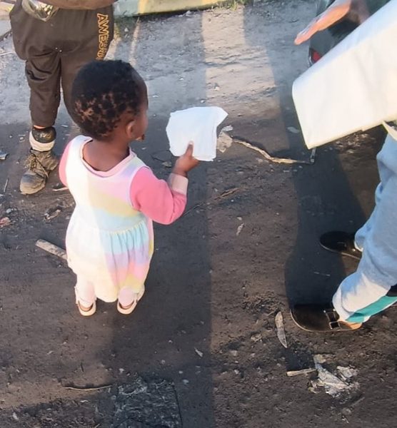 A toddler with her share — the smallest hands of the day.